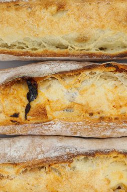 Beyaz arka planda üç taze Fransız ekmeği.