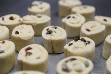 Fırında pişirmeden önce kuru üzümlü çörekler.