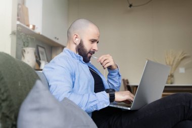 Evden video konferansına sakallı ve gömlekli vahşi bir adam katılıyor. İnternette çalışma ve öğrenim kavramı