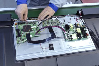 Fabrikadaki TV montaj hattına yakın çekim.