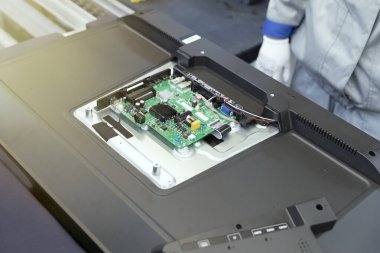 Montaj hattında arka kapağı açık TV