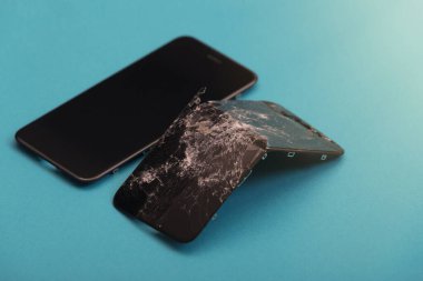 Yeni ekran kırık ekranın yanında mavi bir arkaplanda duruyor.