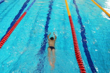 Sporcu temiz suyla havuzda antrenman yapıyor. Üst görünüm