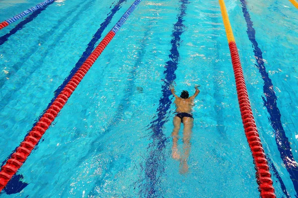 Athlete trains in the pool with clean water. Top view