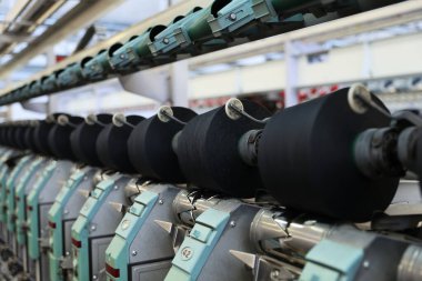 İplik üreten makinelere yakın çekim. İp ve kumaş üretimi için bir fabrika