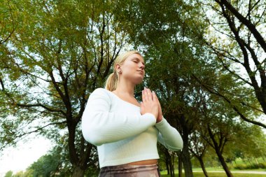 Parkta meditasyon yapan bir kızın portresi.