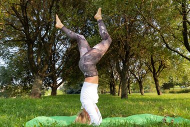 Kız parkta yoga yaparken kafasının üstünde duruyor.
