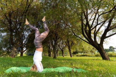 Kız parkta yoga yaparken kafasının üstünde duruyor.