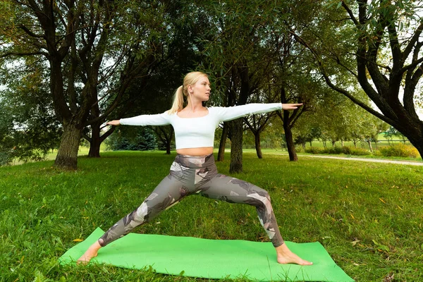Beyaz Tişörtlü Spor Taytlı Sarışın Parkta Halıda Yoga Yapıyor — Stok fotoğraf