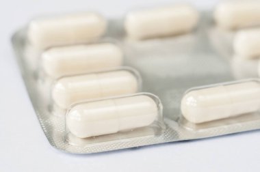Kapalı beyaz antibiyotik kapsül hapları su topladı. Eczane geçmişi. Anti mikrobik ilaç direnci. İlaç sanayisi. Genel sağlık hizmetleri.