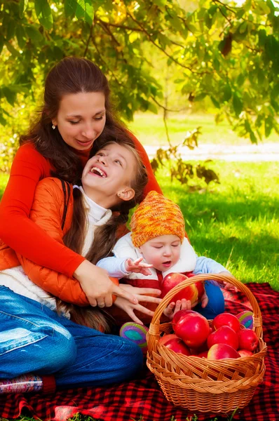 Família com mãe e filhos no parque no outono — Fotografia de Stock