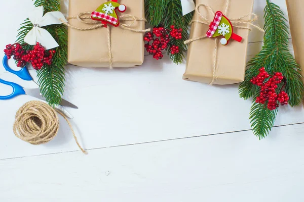 Regalo de Navidad y una ramita de agujas de pino sobre un fondo blanco — Foto de Stock