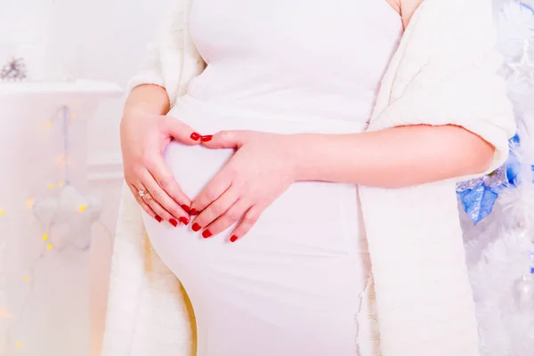 Femme enceinte près d'un sapin de Noël. Le ventre d'une femme enceinte. Une vie saine. Une famille — Photo