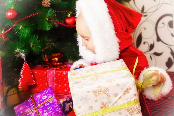 Mały chłopiec w Choinka prezenty w jego ręce. Boże Narodzenie. Prezenty. Świąteczny nastrój. Dzieciństwo — Zdjęcie stockowe