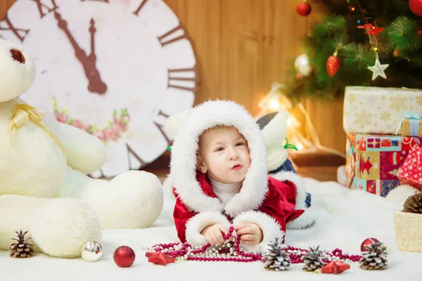 Ragazzino su un albero di Natale con dei regali in mano. Natale. Regali. L'umore festivo. Infanzia. — Foto Stock