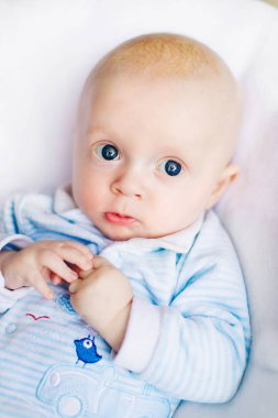 Bebek çocuk beyaz güneşli yatak odasında. Yeni doğan çocuk yatakta rahatlatıcı. Genç çocuklar için kreş. Tekstil ve çocuklar için yatak takımları