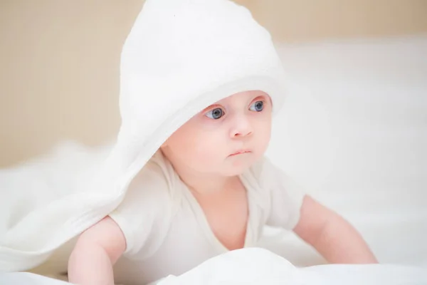 Pequeño bebé sonriendo bajo una toalla — Foto de Stock