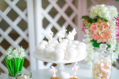 Bir çocuk partisi için pembe renkte çikolata. Havadar balonlar bebek şeker çubuğu ile dekore edilmiş