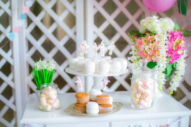 Bir çocuk partisi için pembe renkte çikolata. Havadar balonlar bebek şeker çubuğu ile dekore edilmiş