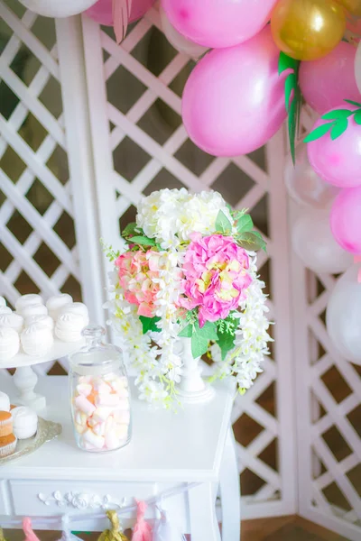 Bir çocuk partisi için pembe renkte çikolata. Havadar balonlar bebek şeker çubuğu ile dekore edilmiş