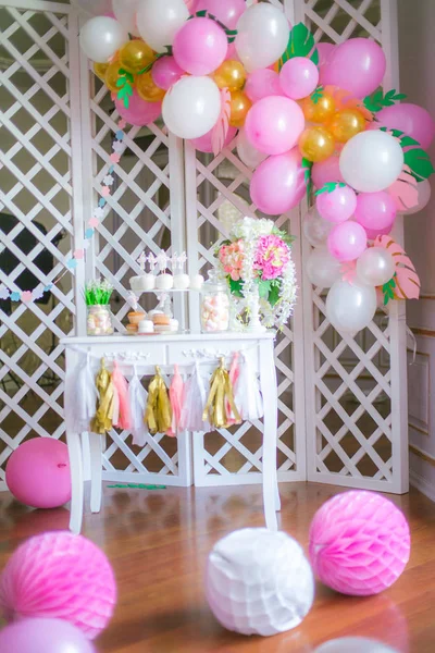 Candy bar in pink colors for a children\'s party. Decorated with airy balloons baby candy bar