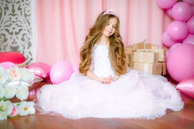 Bir prenses ve taç Balonlu ışık-pembe elbiseli sarışın uzun saçlı kız