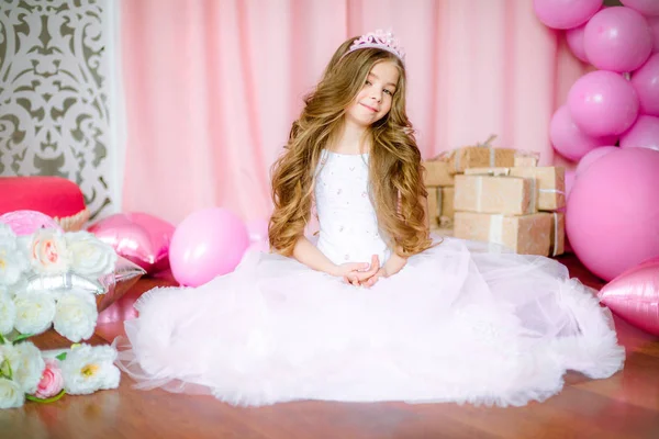 Bir prenses ve taç Balonlu ışık-pembe elbiseli sarışın uzun saçlı kız