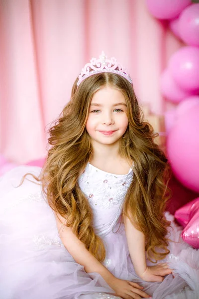 Bir prenses ve taç Balonlu ışık-pembe elbiseli sarışın uzun saçlı kız