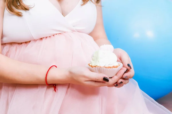 ベビー シャワーのパーティーでピンクのカップケーキを食べる妊婦 — ストック写真