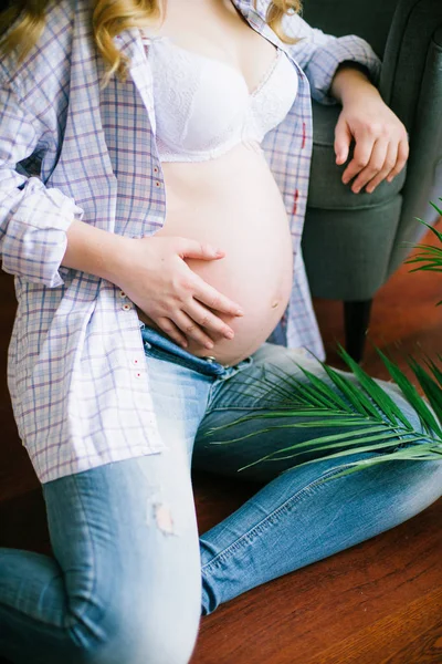 ブルー ジーンズと光のシャツの若い美しい妊娠中の女性 妊娠中の女性と 彼女の手で緑のシダの分岐 エコライフ スタイル — ストック写真