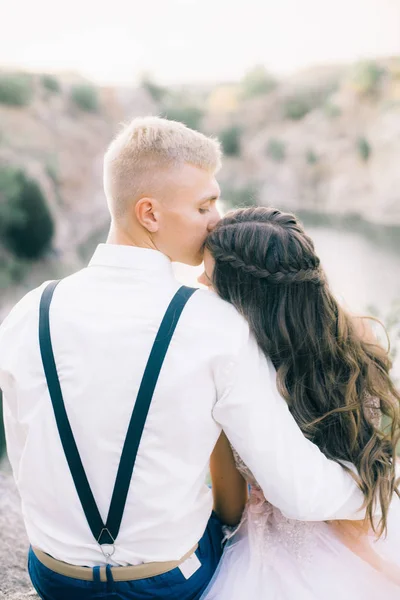 Elegant curly bride and groom outdoors on the background the lake. Groom and Bride. wedding dress. Bridal wedding bouquet of flowers