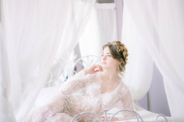 Güzel gelin portresi. Sabah gelin. Düğün sabah. Makyaj. Gelinle koniler ve sarı saçlar. Beyaz dantel sabahlık içinde kırılgan gelin