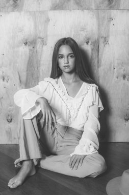 Sarışın ve akşam makyajlı, eski moda pantolonları ve şifonlu bluzu olan çekici bir genç kız. 