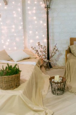 Parlak bir yatak odası, büyük parlak bir yatak odası, çelenklerle süslenmiş bir çatı katı tarzı, iğneli sepetler ve pamuklu dallarla süslenmiş. Yeni yıl 2020. Noel havası