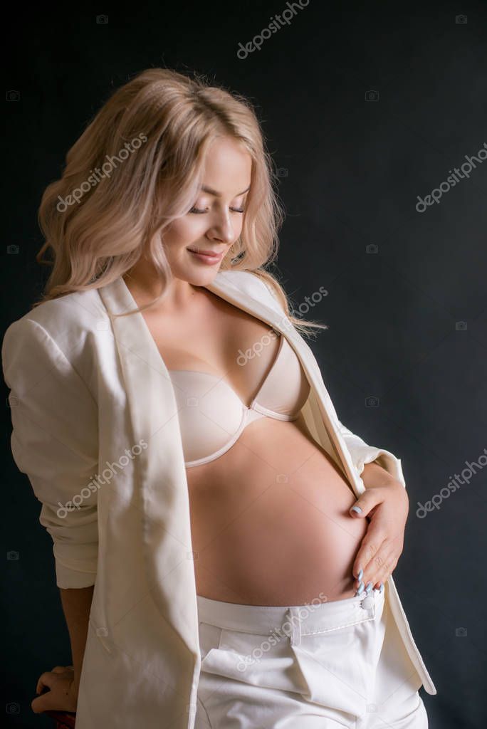 Erotic pregnant beauty in white