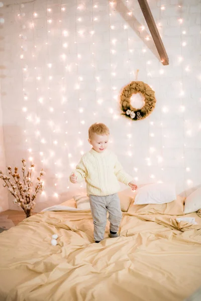 침대의 침실에서 크리스마스 바늘로 장식된 침실에서 금발의 귀여운 크리스마스 분위기 — 스톡 사진