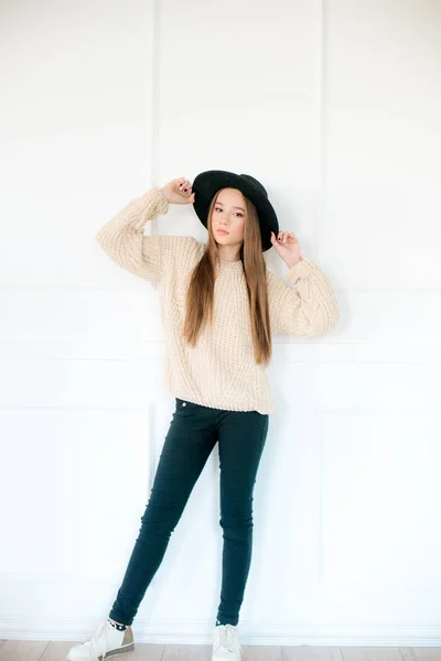 小女孩 穿着温暖的针织毛衣 头戴黑色的毛毡帽 背景是白色的 青少年时尚 — 图库照片