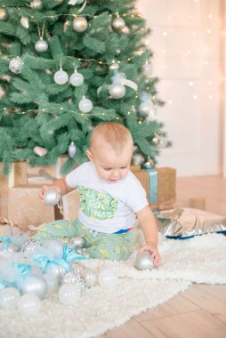 Noel ağacı ve çelenk ve hediyelerle süslenmiş şöminenin yanında tatlı bir çocuk. Noel havası