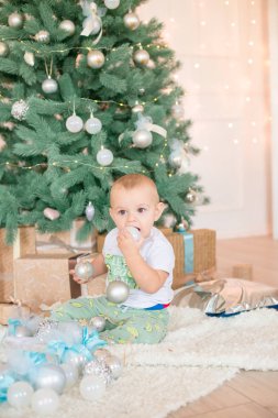 Noel ağacı ve çelenk ve hediyelerle süslenmiş şöminenin yanında tatlı bir çocuk. Noel havası