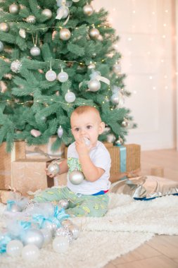 Noel ağacı ve çelenk ve hediyelerle süslenmiş şöminenin yanında tatlı bir çocuk. Noel havası