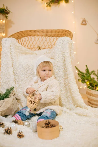Χαριτωμένο Κοριτσάκι Ένα Λευκό Πλεκτό Πουλόβερ Κάθεται Ένα Λευκό Καρό — Φωτογραφία Αρχείου
