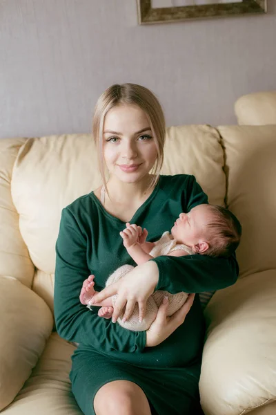 自宅で彼女の腕の中で赤ちゃんと若い美しいブロンドの髪のママソ 幸せな母親 — ストック写真
