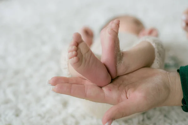 Las Manos Mamá Sostienen Pequeñas Piernas Lindas Bebé Que Yace —  Fotos de Stock