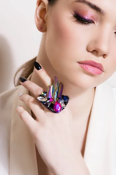 Attractive girl model with evening make-up and hairstyle with beautiful fashion jewelry. Beauty and Fashion