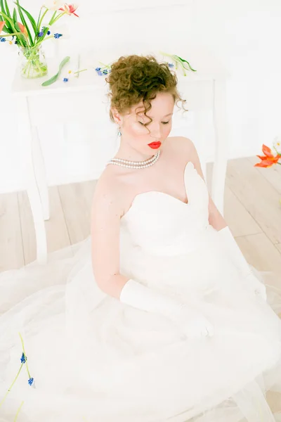 チューリップで飾られた光の春のスタジオで白いドレスで魅力的な若い花嫁 美とファッション — ストック写真