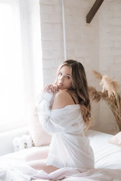 可爱的小女孩 早上在卧室里 一头长长的卷曲的金发 穿着漂亮的花边睡衣和白衬衫 — 图库照片