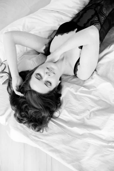 Uzun Kıvırcık Saçlı Dantelli Siyah Takım Elbiseli Yatak Odasındaki Yatakta — Stok fotoğraf