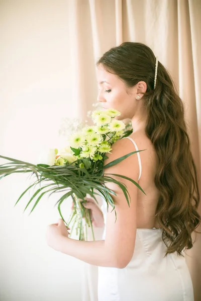 スタジオで花の結婚式の花束と白いドレスで長い髪のアジアの外観のかわいい柔らかい若い花嫁 — ストック写真