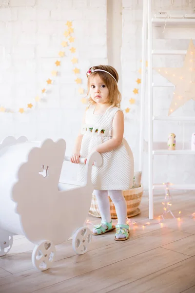 Μικρό Χαριτωμένο Κορίτσι Ένα Λευκό Φόρεμα Παίζει Ένα Λευκό Πάσσαλο — Φωτογραφία Αρχείου