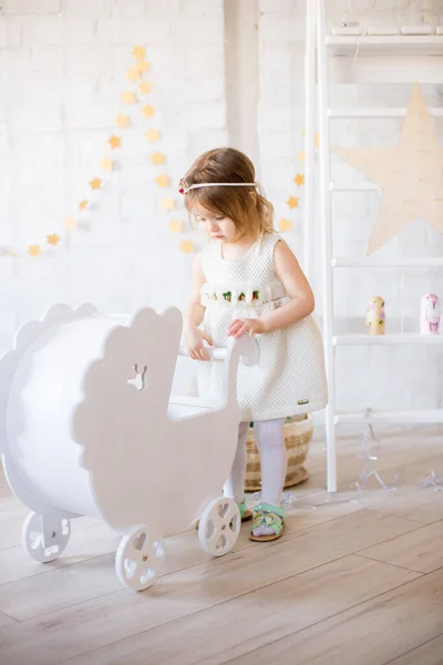Beyaz Elbiseli Küçük Şirin Kız Oyuncak Çelenklerle Süslenmiş Parlak Bir — Stok fotoğraf